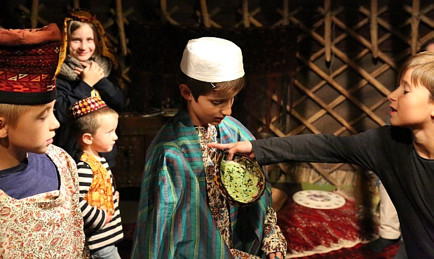 Kinder in einer Turkmenen-Jurte mit ortstypischen Kleidungsstücken